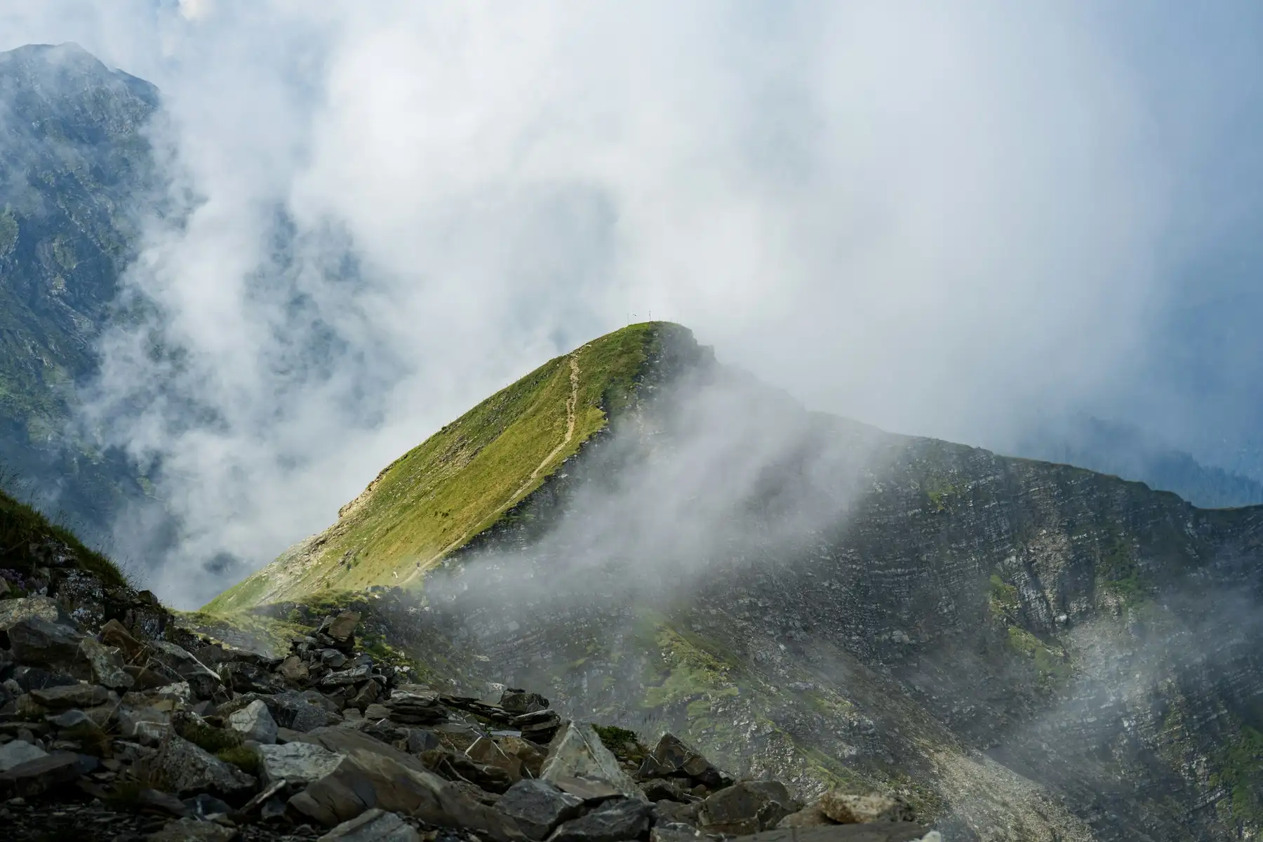 A mountain ridge rising through drifting cloud