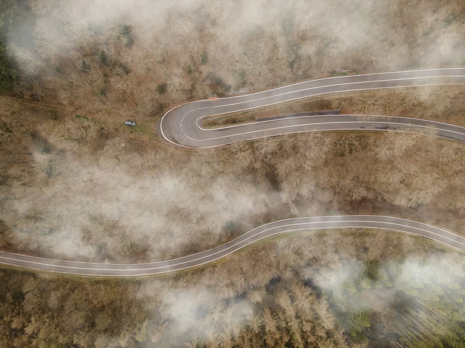 A road finding a clear line through mist